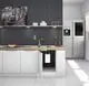 Kompakte weiße Heizungsinstallation in moderner Küche mit Holzarbeitsplatte, ausgestattet mit Wandregal, Geschirr und Obstschale. Stiebel Eltron Produkt sichtbar unter Spüle.